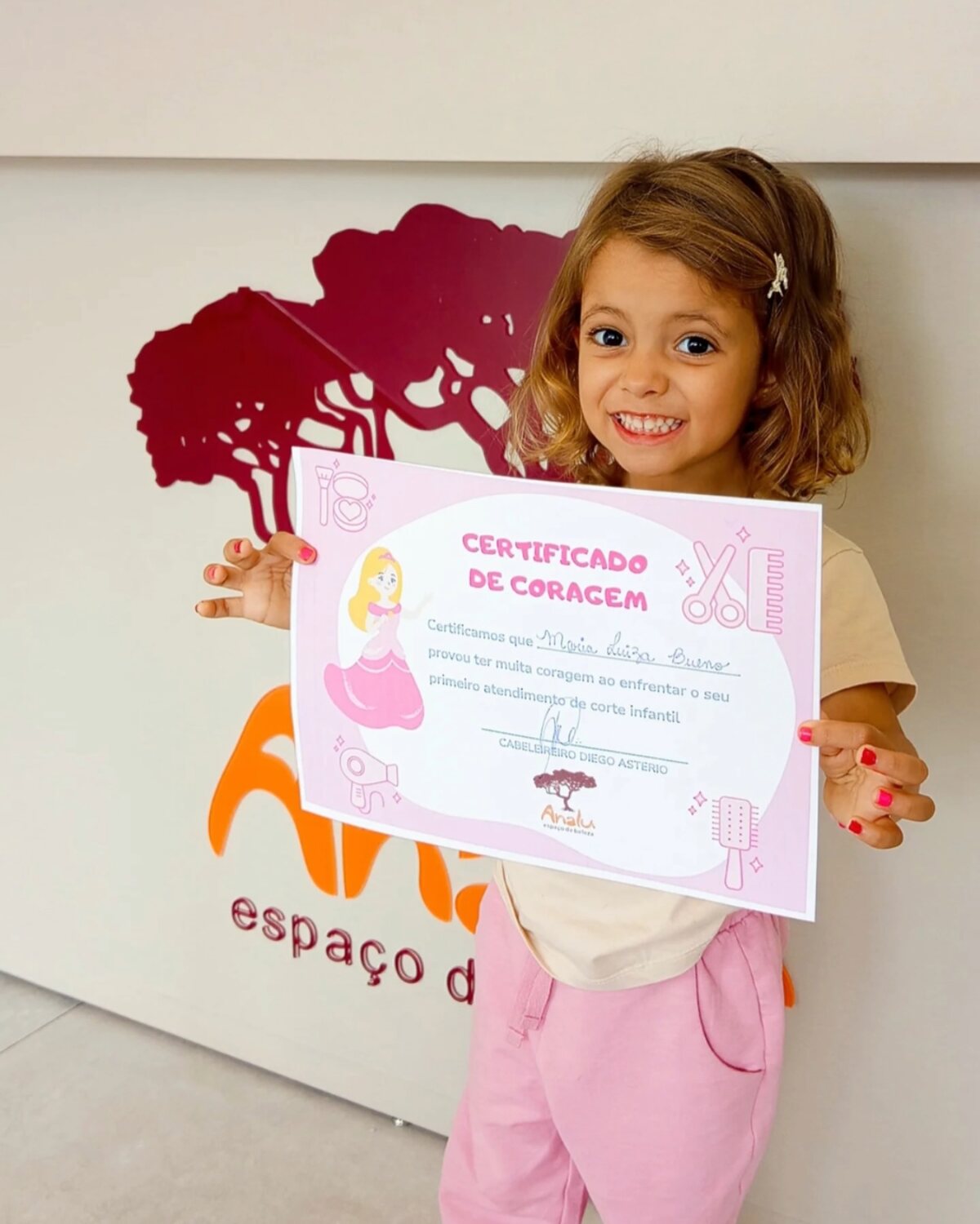 Criança com o Certificado de Coragem do Analu Espaço de Beleza