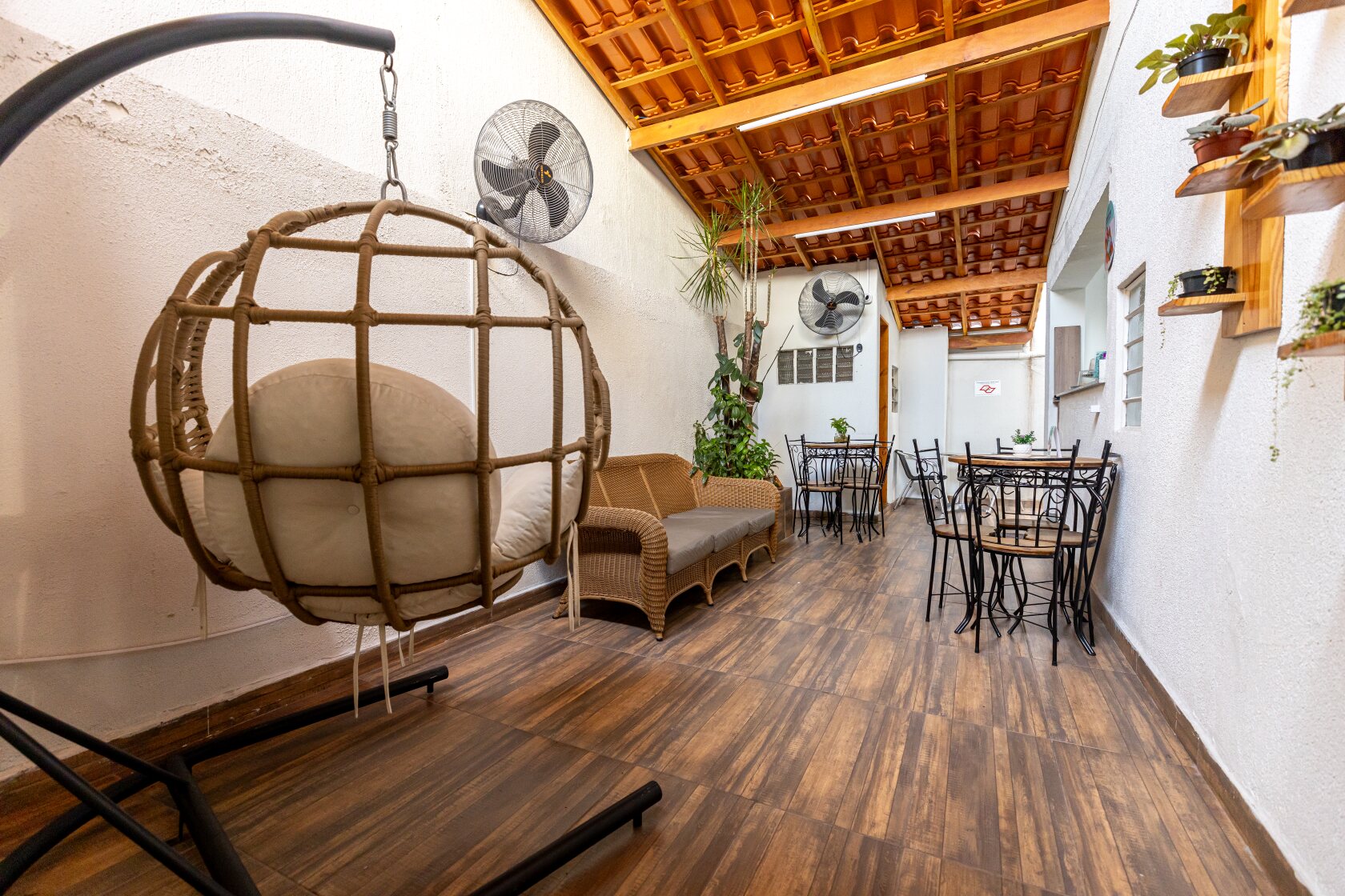 Lounge aconchegante do Analu com cadeira suspensa